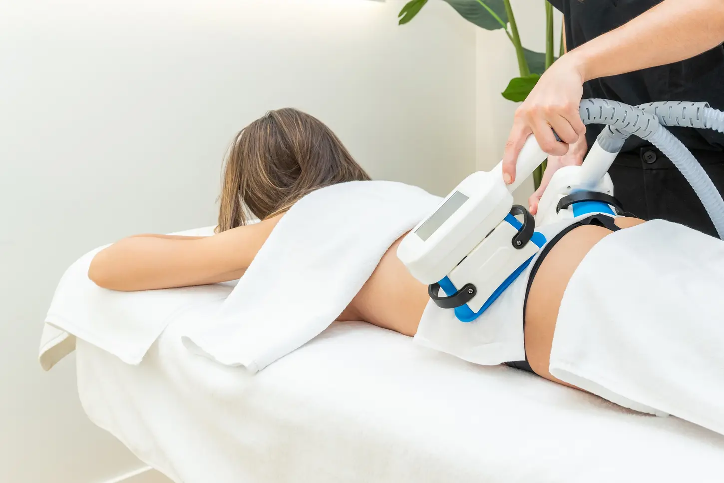 Therapist applying cryolipolysis treatment